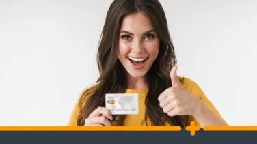 Uśmiechnięta kobieta z kartą płatniczą pokazująca kciuk w górę